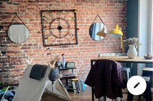 Cette chambre dispose d'un mur en briques avec miroirs et d'une table. dans l'établissement Le 5 Brest, à Brest