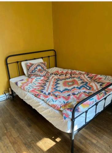 - un lit avec une couette colorée dans l'établissement Le 5 Brest, à Brest