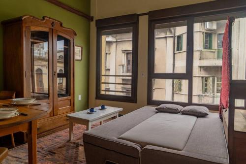 a bedroom with a bed and a table and windows at Taylor's Port [3] Landing in the Old Town in Montevideo