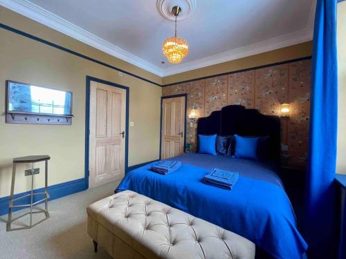 a bedroom with a blue bed and a couch at The Bedford Inn in Ramsgate