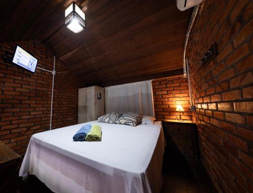 a bedroom with a bed in a brick wall at Residencial Caminho das Ondas in Bombinhas