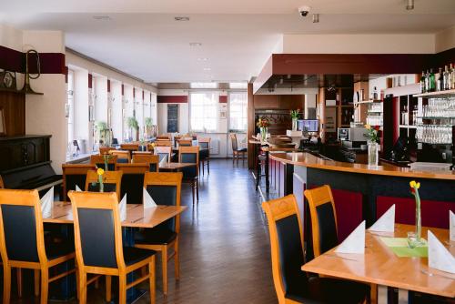 un restaurant avec des tables et des chaises en bois ainsi qu'un bar dans l'établissement Hotel Landgasthof Zur Alten Scheune, à Zweibrücken
