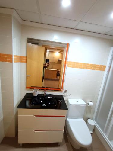 a bathroom with a toilet and a sink and a mirror at Romántico Daimús 2 in Daimuz