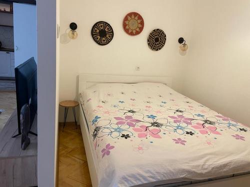 a bedroom with a bed with flowers on the wall at City Center Studio Apartment in Gjakove