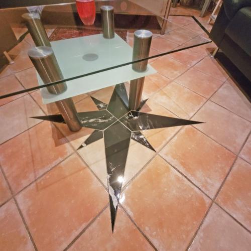 a glass table on a tiled floor with two poles at Apartment close to nature,airport, fair in Ratingen