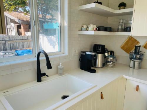 a kitchen counter with a sink and a window at Vacation House 2-Bedroom 1 Bathroom in Beach Town with Full size Kitchen and free onsite parking and laundry - Great for solo, couple, family and business travelers in Manhattan Beach