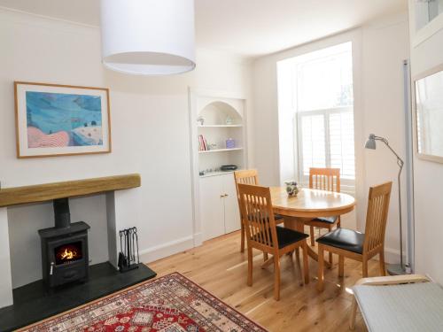 a living room with a table and a fireplace at 6 Kirkstyle in Biggar