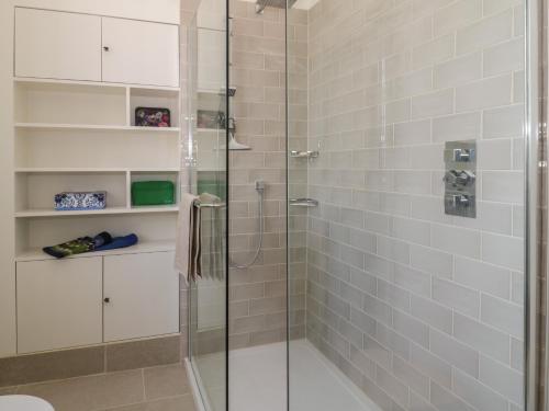 a bathroom with a shower with a glass door at 6 Kirkstyle in Biggar