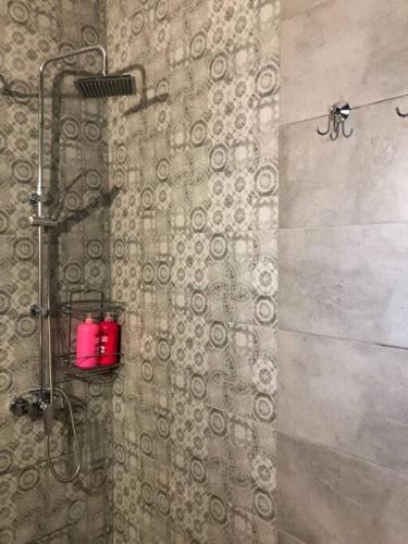 uma casa de banho com um chuveiro com uma vela vermelha em Boutique Apartment in the Center of Ioannina em Ioannina