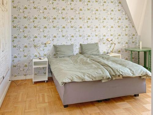 a bedroom with a bed and a wall with flowers at Holiday home VETLANDA in Vetlanda