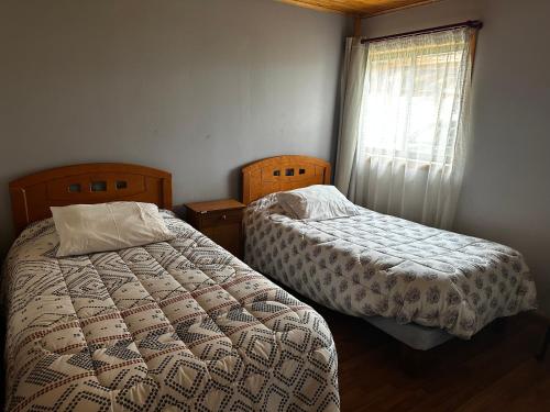 1 dormitorio con 2 camas y ventana en Vista Alegre, en Parral