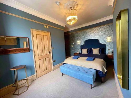 a blue bedroom with a bed and a tv at The Bedford Inn in Kent