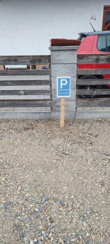 a blue parking sign in front of a fence at Be Home! Apartment Gratkorn in Gratkorn