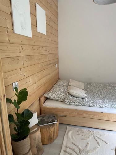 um pequeno quarto com uma cama numa parede de madeira em Strefa medytacji em Wólka
