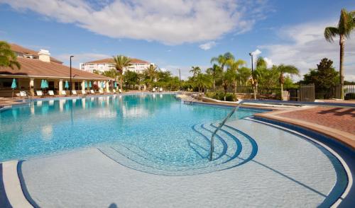 ein großer Pool in einem Resort mit Palmen in der Unterkunft Fabulous Vista Cay Luxury Rhapsody Near all Theme Parks, walk to the Convention Center in Orlando