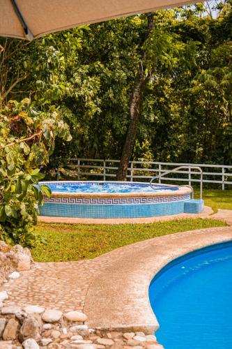 a swimming pool in a yard next to at Hotel Nututun Palenque in Palenque
