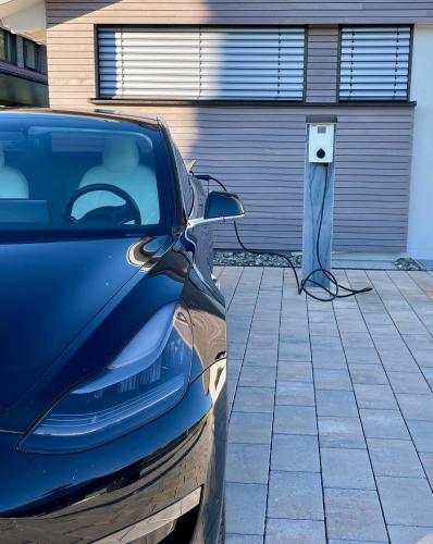 a car parked in front of a garage with a charging station at STERK Apartments - idyllisch - modern - stilvoll in Meckenbeuren