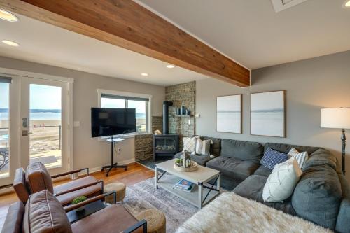 a living room with a couch and a tv at Coastal PNW Home on Swimmable Beach with Hot Tub! in Stanwood