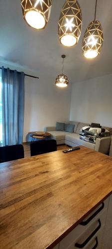 a living room with a large wooden table and lights at Apartament z tarasem Kutno in Kutno