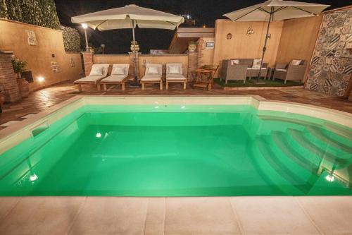 a large swimming pool with a table and umbrella at Villa Alecla - Sea Villa near Taormina in SantʼAlessio Siculo