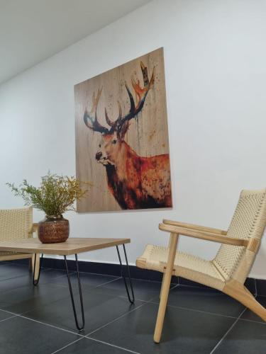 a painting of a deer on a wall next to a table at Hotel Puerto Triunfo in Doradal