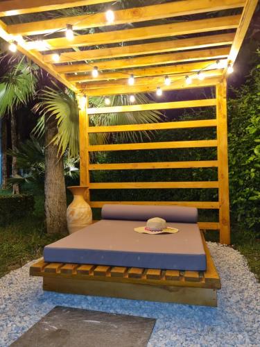 a bed in a garden with a pergola at Hotel Puerto Triunfo in Doradal