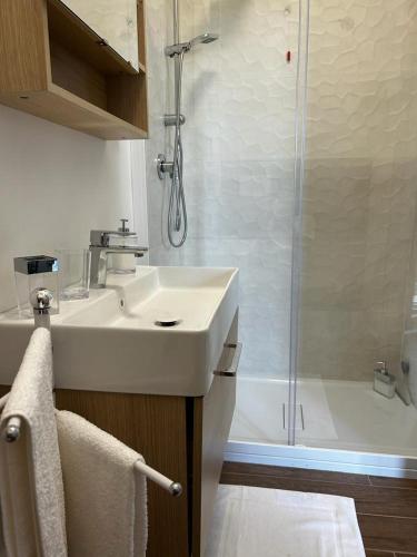 a white bathroom with a sink and a shower at B&B la casa di Polly in Falconara Marittima