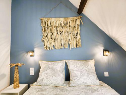 een slaapkamer met een bed en een blauwe muur bij La Noé d'Or by Madame Conciergerie in Bruz