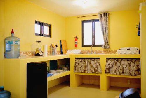 a yellow bathroom with a sink and a counter at Cerritos Beach Palace Casa Gaia in El Pescadero