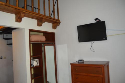 a room with a tv on a wall with a dresser at Hotel Meson del Mar in Veracruz