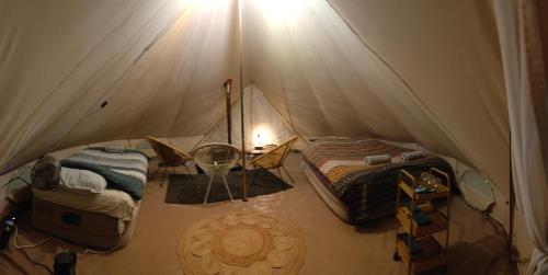 a tent with two beds and a table in it at Au Pied Du Trieu, the glamping experience in Labroye
