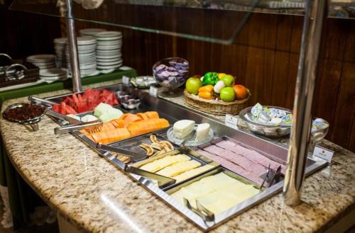 un buffet con queso y fruta en una mesa en GOLDMEN HOTEL MARINGÁ en Maringá