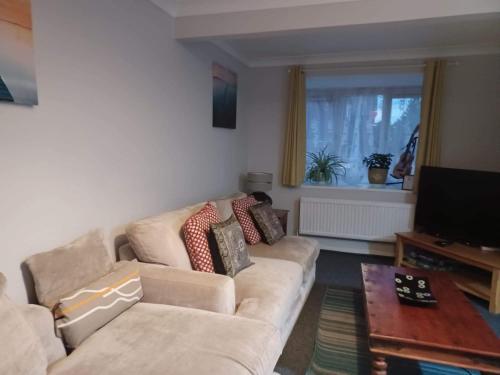 a living room with a couch and a television at Fieldfare Green-Huku Kwetu Luton & Dunstable Spacious 4 Bedroom Detached House in Luton