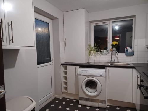 a kitchen with a washing machine and a sink at Fieldfare Green-Huku Kwetu Luton & Dunstable Spacious 4 Bedroom Detached House - Free Parking- Field View-Affordable Group Accommodation - Business Travellers in Luton