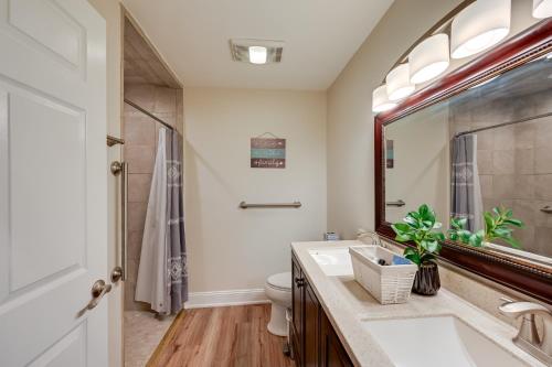a bathroom with a sink and a toilet and a mirror at Lovely Goldsboro Home with Yard and Grill! in Goldsboro