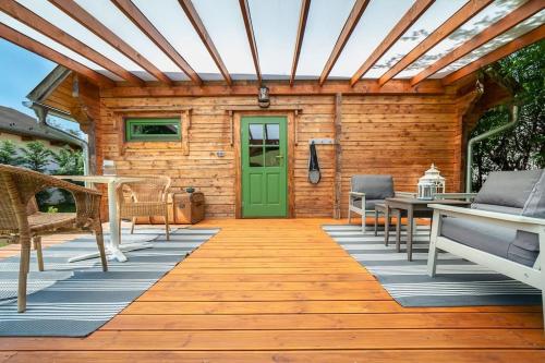 a wooden deck with a green door on a cabin at Mannana házikó in Szokolya