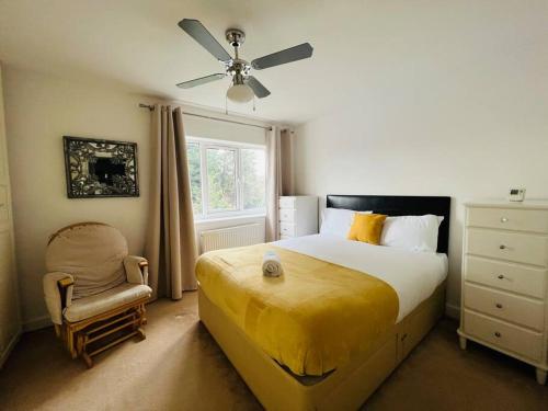 a bedroom with a bed with a ceiling fan and a chair at Gytes Lane, Manchester with FREE Parking and FREE Wi-Fi in Manchester