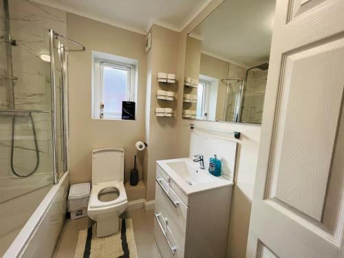 a bathroom with a toilet and a sink and a shower at Gytes Lane, Manchester with FREE Parking and FREE Wi-Fi in Manchester
