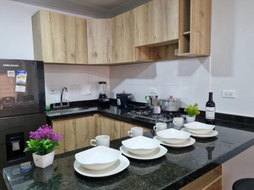 een keuken met witte gerechten op een aanrecht bij Apartahotel AMARU in San Gil