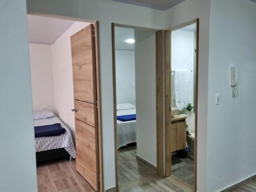 een kamer met een spiegel en een slaapkamer met een bed bij Apartahotel AMARU in San Gil