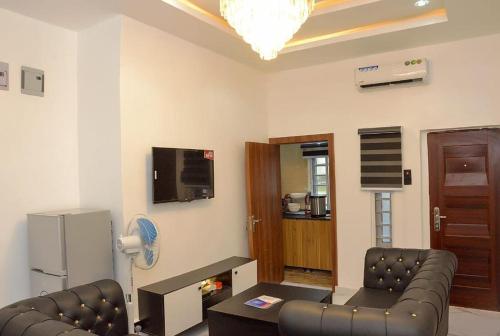 uma sala de estar com dois sofás e uma televisão em Hemistry em Ikeja