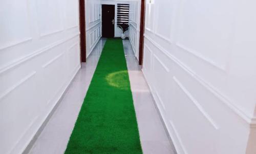 um corredor com relva verde num edifício branco em Hemistry em Ikeja