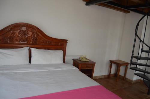 a bed with a wooden headboard in a room at Hotel Meson del Mar in Veracruz