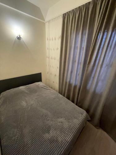 a small bedroom with a bed and a window at Natalies apartment in Yerevan