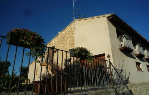 a building with potted plants and a fence at Hort de L'Aubert in Cretas