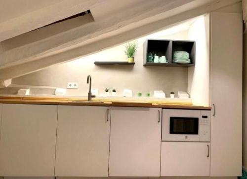 eine Küche mit weißen Schränken und einem Waschbecken in der Unterkunft LITTLE SKY in Madrid