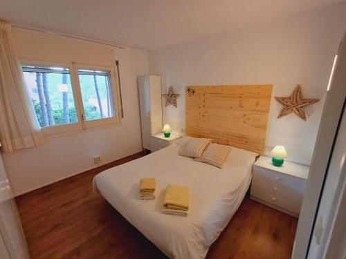 a bedroom with a bed with two yellow towels on it at Apartamento con piscina y wifi cerca de la playa in Pals