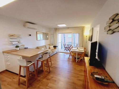 cocina y sala de estar con mesa y sillas en Apartamento con piscina cerca de la playa, en Pals
