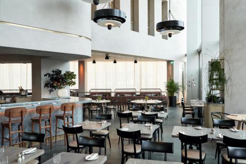 a restaurant with tables and chairs and a bar at Manhattan Loft Gardens, Stratford in London
