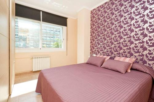 ein Schlafzimmer mit einem lila Bett mit einer Wand in der Unterkunft Glorias:Sagrada Familia 15 minutos - Playa 20 minutos in Barcelona